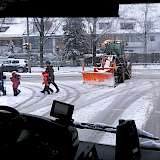 Fahrzeug mit Schneeschild räumt verschneite Straße